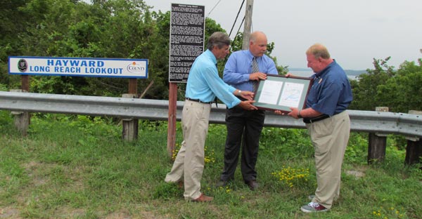 Dr. Andre Lapierre and Morgan Goadsby, of the Ontario Geographic Names Board, present Mark Hayward with a commemorative plaque.