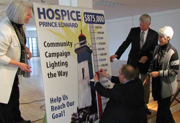 Hospice President Birgit Langwisch and Community Campaign Honourary Chairs Lyle and Sharon Vanclief, watch as Wayne Carruthers marks the half way to goal on the fundraising thermometer.