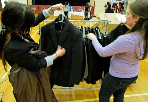 Loyalist intern Kayla Paradis and PECI student Shannon Langridge hang the suits donated to to this year's Prom Project event.