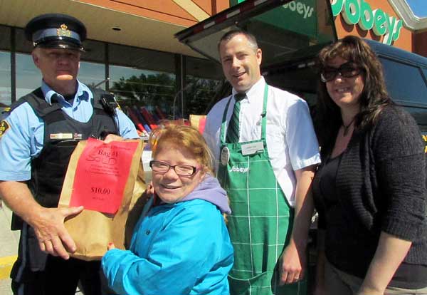 PEC OPP auxiliary Sgt Rick Campbell, Hannah Daley-Jewell of Northport, Sobeys owner Jamie Yeo and Picton Foodbank volunteer Tracy Steen at the Cram the Cruiser event this week.