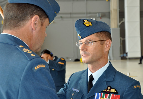 Col. David Lowthian receives the 8 Wing command pennant from Major-General St. Amand during the Change of Command ceremonies Wednesday. Photo Ross Lees