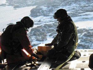 Search and Rescue crew on board a CC-130 Hercules from 424 Squadron based at 8 Wing, Trenton, Ont., prepare a radio before dropping it to enable the stranded hunters establish ground communications.