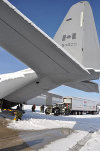 The loading process begins as the toys and diapers are moved from the transport to the Hercules aircraft. - Photo Ross Lees