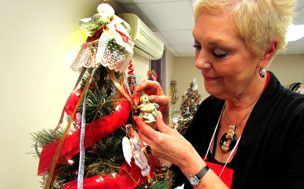 Dorothy Vincent Speirs, communications rep for the PECM Hospital Auxilary, puts the finishing touches on an angelic tree she donated to the weekend's fundraiser.