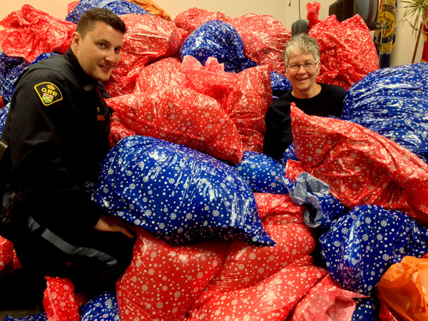 Anthony Mann and Barb Sills with the bags of winter clothing to help warm 163 Prince Edward County children this winter.