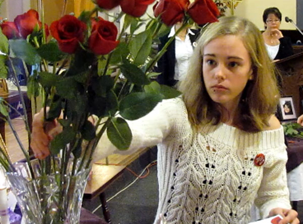 Larissa Lewis places a rose during the National Day of Remembrance and Day of Action event held at St. Andrew's Church, Picton.