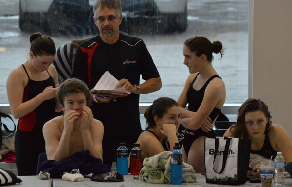 Resting between swims, with Coach Jim Anfield, are Dolphin Club swimmers Kelli-Anne Maycock, Faith Elsbury, Colm O'Sullivan, Abby Taylor and  Morgan Clark.