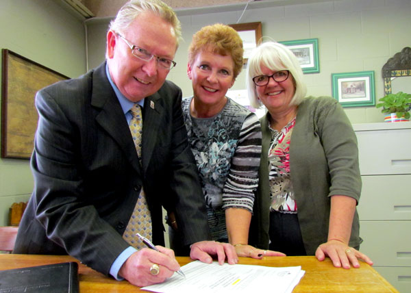 North Marysburgh councillor Robert Quaiff signs his nomination forms in the presence of Prince Edward County Clerk Kim White and his wife, Susan Quaiff.
