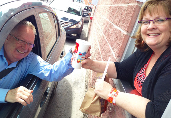 Robert Quaiff receives a McCafe from Hospice Executive Director Nancy Parks, working at the McHappy Day window at McDonalds.