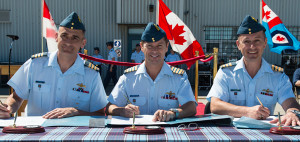 From left, incoming Lieutenant-Colonel Dany Poitras, Colonel David Lowthian, 8 Wing's Wing Commander and reviewing Officer and outgoing LCol Jean Bernier pose before signing the official transfer of command documents. - Photo by Corporal Owen W. Budge, 8 Wing Imaging © 2014 DND-MDN Canada