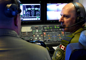 Flight Refueling Specialist Leader, Royal Canadian Air Force (RCAF) Major Gary Giacomuzzo speaks with Captain Scott Woods aboard a RCAF CC-150T Polaris during a refueling mission just off the coast of Hawaii for the Rim of the Pacific (RIMPAC) Exercise 2014. Photo by Sgt Matthew McGregor, Canadian Forces Combat Camera 