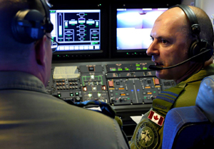 Flight Refueling Specialist Leader, Royal Canadian Air Force (RCAF) Major Gary Giacomuzzo speaks with Captain Scott Woods aboard a RCAF CC-150T Polaris during a refueling mission just off the coast of Hawaii for the Rim of the Pacific (RIMPAC) Exercise 2014. Photo by Sgt Matthew McGregor, Canadian Forces Combat Camera