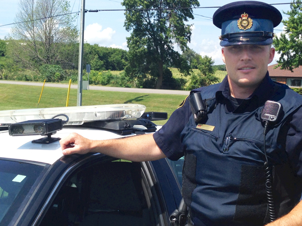 Officer Anthony Mann with the ALPR camera mounted on the roof of the OPP vehicle.