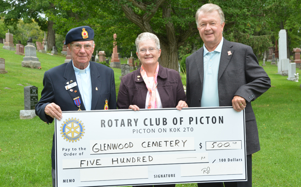 Rev. William Kidnew, Padre of Branch #78 Royal Canadian Legion and Sandra Latchford, Chair of Glenwood Cemetery Board, accept a $500 donation from Rick Jones, President of The Rotary Club of Picton.