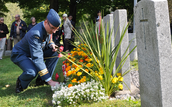 Lt.-Col. Andrew Wedgewood places a poppy on one of six graves pictured here at Gelenwood Cemetery. Photo by Ross Lees 