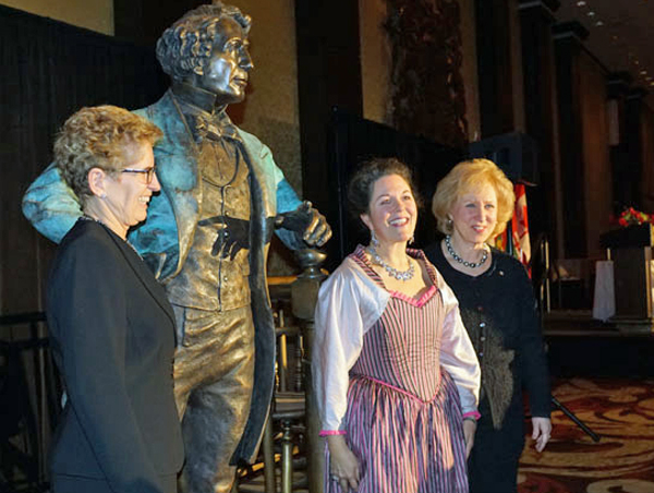 Premier Kathleen Wynne, poses beside Sir John A Macdonald, his artist Ruth Abernathy and former prime minister Kim Campbell.