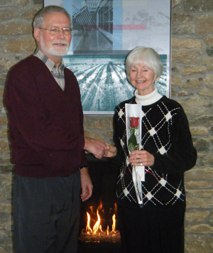 Jon Leavens, president Alzheimer Society of PEC, presents June the first stem of a bouquet of roses donated by Flowers & Such that she would collect during the evening. 