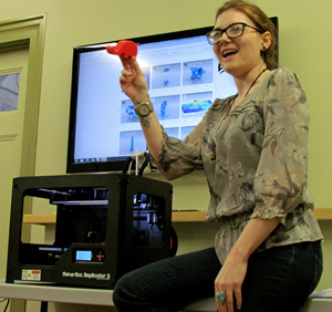 Amanda Harrison shows a cell phone holder she created with the new 3D printer.