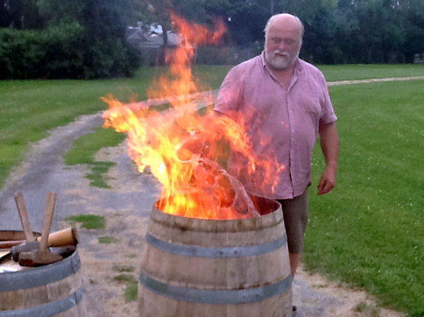 Peter Bradford demonstrates the "toasting" of wine barrels to prepare them.