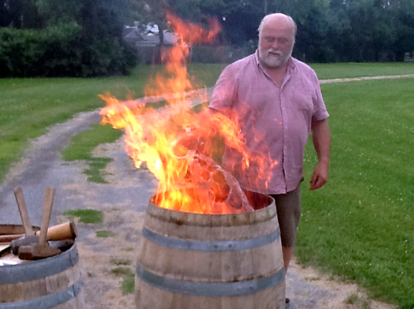 Peter Bradford demonstrates the "toasting" of wine barrels to prepare them.