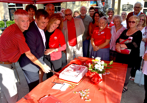 Lyle Vanclief, former MP and Agriculture Minister in this riding, Neil Ellis and his wife Sue, gather to cut the cake as supporters look on.