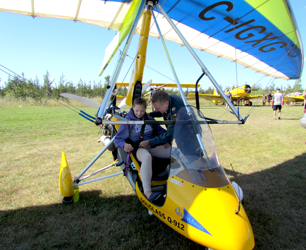 Jeff Douglass buckles Destiny, an aviation instructor with the Air Cadets, into his Trike.