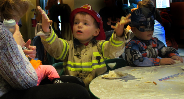 Firefighter Asher Roloson shows his mum his hands full of doughy fun.