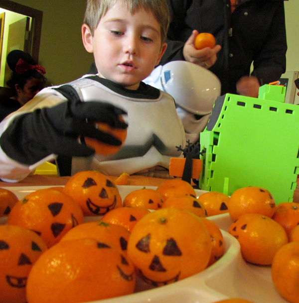 Stormtrooper Ethan Maw chooses a mandarin 'pumpkin' from the snack table.