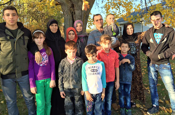 Most of the members of the family: Abdel Malek and his wife Sawsen, his mother Hadji, and their children Slieman, Ramez, Khatim, Ahmed, Rahef, Siham, Walaa, Alaa, Mijed, Bachar, and the baby Fadl pose for a photo. - Carlyn Moulton photo