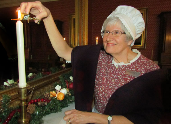 Margaret Davies welcomes visitors to the Candlelight Wassail, in the parlour.