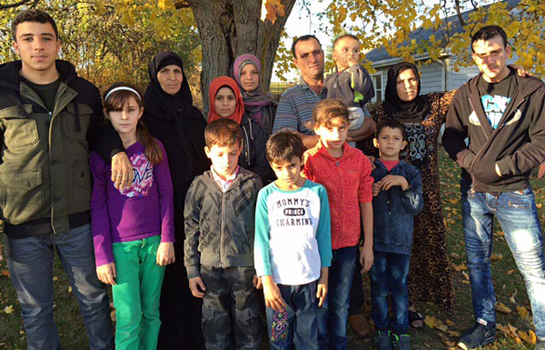 Most of the members of the family: Abdel Malek and his wife Sawsen, his mother Hadji, and their children Slieman, Ramez, Khatim, Ahmed, Rahef, Siham, Walaa, Alaa, Mijed, Bachar, and the baby Fadl pose for a photo. – Carlyn Moulton photo