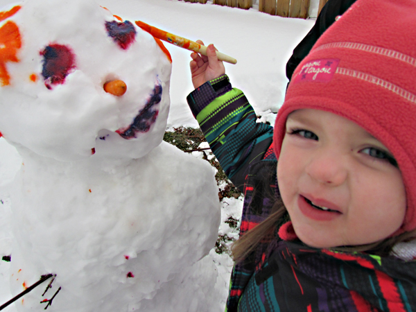 Ayla, 3, paints a happy face on Connor, the Snowman.