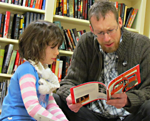 Norah listens to her dad Justin read Robert Munsch's The Fire Station.