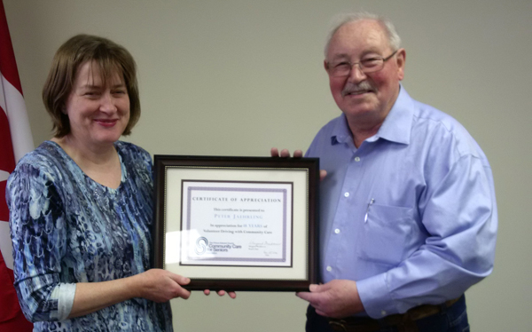 Lorna MacDonald, from Community Care, presents a certificate of appreciation to volunteer driver Peter Jaehrling to mark his retirement after driving seniors for 18.5 years.