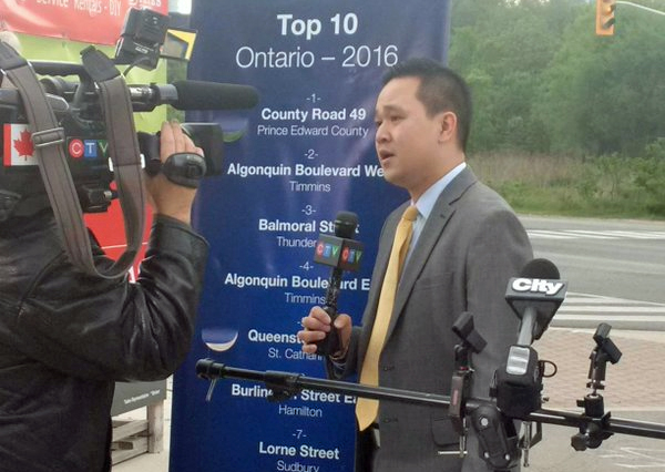 Ray Chan speaks with the media following CAA's worst roads announcement this morning in this photo posted on CAA's Twitter account.