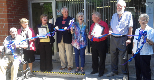 At the ribbon cutting at the official opening of the Community Care & VON space at 74 King Street in Picton, from left, are: Morley Conley, VON client and his daughter Monica Hobson; Todd Smith MPP office representative Susan Smith; Klaus Rohrich, vice-chair of Community Corporation of VON Hastings Northumberland Prince Edward Board; Margaret Werkhoven, Chair of Community Care; PEC Mayor Robert Quaiff; Ralph Hall, Chair of Community Care Foundation, volunteer driver, and client; Edith Morash Community Care Thrift Shop & Meals on Wheels volunteer. - Susan DeWolfe photo