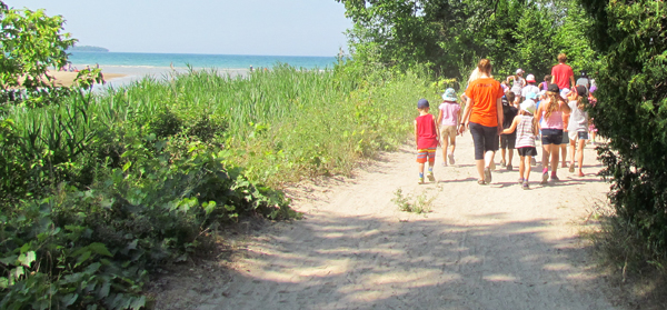 About 28 children participating in a new summer camp at St. Gregory's School head down to the beach to build sand castles.