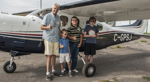 Bradley Stever, 8, Brandon Bergeron, 11, and Brendan Robins, 12, ready to take flight with pilot Phil St. Jean.