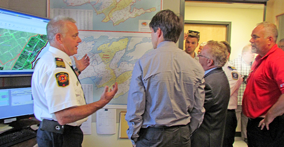 PEC Fire Chief Scott Manlow explains the County's geography to Dr. Eric Hoskins, Minister of Health, on a visit to the new fire hall's dispatch centre. Mayor Robert Quaiff and MPP Todd Smith also answered Hoskins' questions.