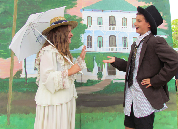 Miss Lauren Bauman and Master Cameron Bauman, of Barrie, dressed in the style of the day and posed infront of a painting of the Lodge.