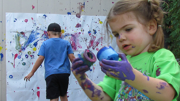 Halle checks her paints while Jack applies his artistic touch to the wall painting area at the HUB Saturday.