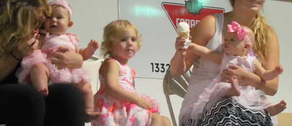 Lilah looks over the crowd as her sister Corah Craig reaches for her ice cream while awaiting the judges.