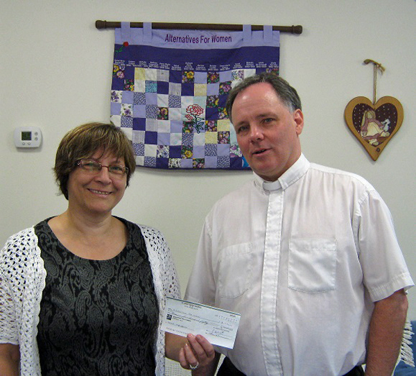 Rahno Boutilier, Alternatives for Women Executive Director received the donation from Rev. Cannon David Smith, of St. John’s Anglican Church, Waupoos.