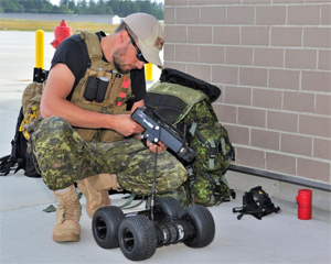 A member of a Canadian Armed Forces Explosive Ordnance Disposal team prepares equipment to be used in the examination of a simulated Improvised Explosive Device (IED) during Exercise ARDENT DEFENDER. Photo: LS Zachariah Stopa, MARPAC Imaging Services