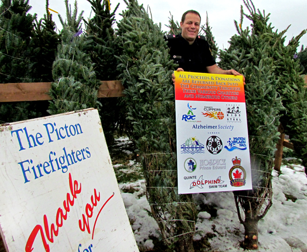 Firefighter Tim Kraemer with Balsam and Fraser Fir trees now available at the Picton station’s new 8 McDonald Drive location. Trees are $45 each. All proceeds assist the firefighters in their support of various County charities.