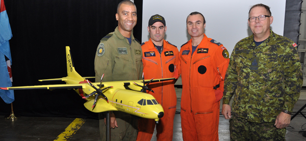 424 Transport and Rescue Squadron Commander Lt.-Col. Leighton James, Sar Techs MCpl. Chris Auger and Sgt. Gord Hynes, and Chief Warrant Officer Brian Wilson gather around the model of the Airbus C295W displayed during the announcement of the purchase of the new aircraft at 9 Hangar on CFB Trenton Thursday. Ross Lees photo