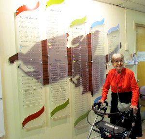 Irena Camp by the PECMH donor wall, where she moved to Patron level honouring donations between $10,000 and $24,999.